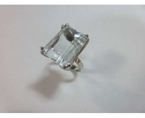 A single stone aquamarine ring, the 1.5 x 1.1cm step cut aquamarine double claw set above four crescents to a plain tapered b