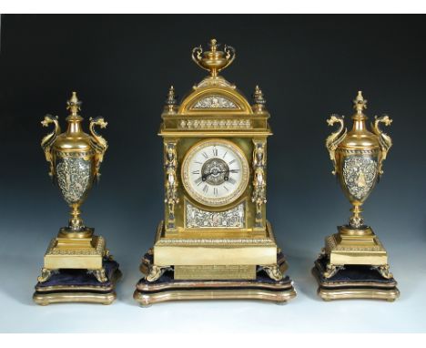 A French 19th century gilt and decorated clock garniture, the urn topped case above arch and four lobed finials, balustrade f