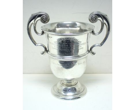 The Claymore Cup - a silver two handled trophy cup, by Walker and Hall, Sheffield 1909, of inverted bell shape with moulded e