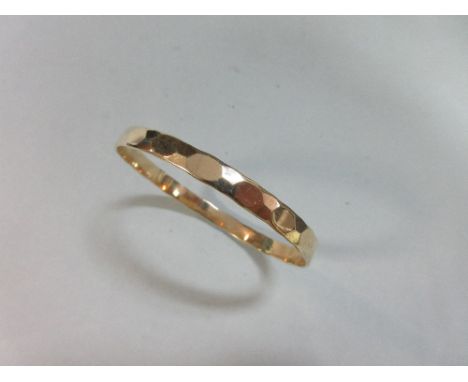 A 9ct gold bangle, the 6mm wide uniform circular bangle with softly faceted exterior pattern, diameter 6.5cm, weight 16g  