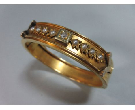 An antique neo-classical style hinged bangle with diamond and seed pearls, the uniform 1.2cm wide bangle set to the front wit