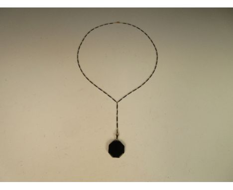 An art deco Tiffany & Co black enamel pendant and matching chain, the hexagonal pendant enamelled on both sides, to a similar
