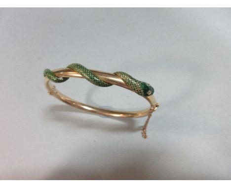 An enamelled snake-entwined hinged bangle, the oval section hollow bangle loosely encircled round the front by a lightly-arti