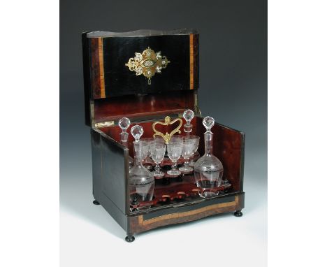 A 19th century French decanter box, the ebony and amboyna case with mother-of-pearl and brass inlay opening to reveal four de