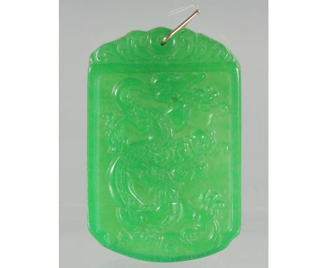 A CARVED JADE PENDANT with gold ring. 2.25ins
