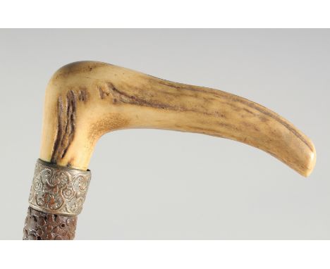 A GOOD VICTORIAN WALKING STICK with carved bone handle and silver band.