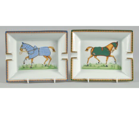 A PAIR OF HERMES PORCELAIN ASHTRAYS decorated with horses. 7.25ins long.