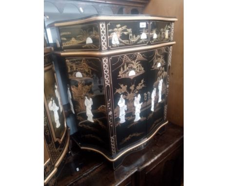 A Chinese black lacquer and gilt decorated side cabinet with mother of pearl relief figures. 