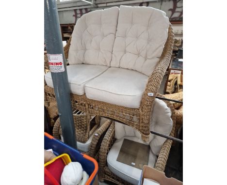 A cane conservatory suite comprising two seater sofa, two armchairs and a coffee table. 