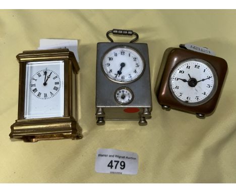 A miniature brass carriage clock and two other miniature clocks. 