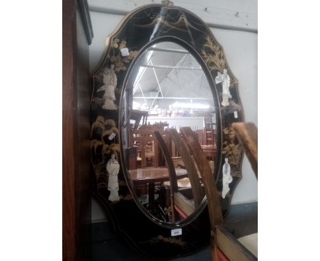 A Chinese black lacquer and gilt decorated mirror with mother of pearl relief figures. 