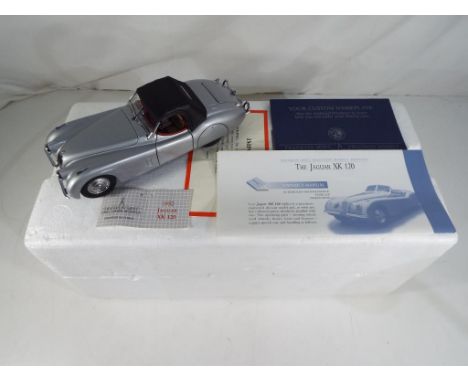 Franklin Mint - a 1:24 scale Jaguar XK120, comes with owners small manual and paperwork, model appears m with polystyrene pac