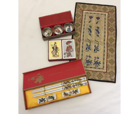 Comprising: A Chinese embroidered silk mat 38 x 10.5cm, a boxed set of 3 small ceramic bowls, set of playing cards containing