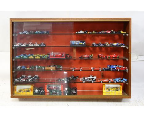 A large selection of collectable racing cars in glass display cabinet - includes examples such as Michael Schumacher's Ferrar