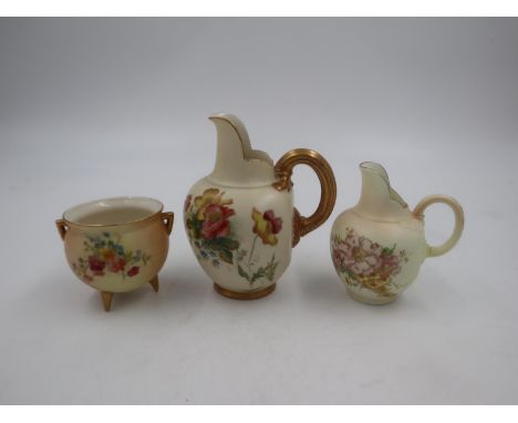 Three pieces of Royal Worcester Blush Ivory ware, two flat back jugs and a small twin handled pot on tri-form supports. Talle