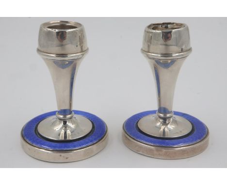 Hallmarked silver pair of candlesticks, each with guilloche enamelled border to bases, one having damage to the top rim and s