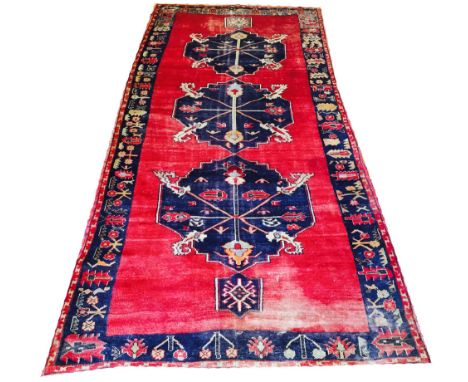 VINTAGE ANATOLIAN KELLEH, 350cm X 175cm, triple midnight blue medallions on a ruby field within corresponding border. 