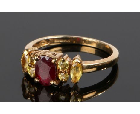 9 carat gold garnet set ring, with a central garnet flanked by yellow stones, ring size O