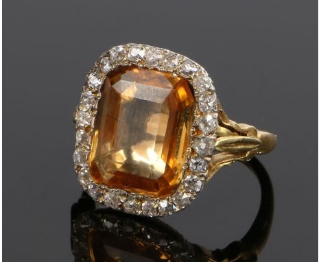 Topaz and diamond set ring, the central certificated natural yellow topaz at 5.62 carat approximately within a diamond surrou