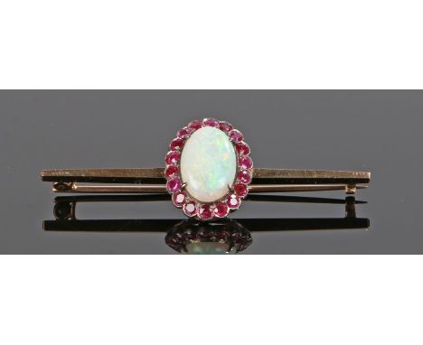 Opal and ruby brooch, the cabochon cut central opal at 13mm long with a ruby surround mounted to the bar, the bar 53mm long