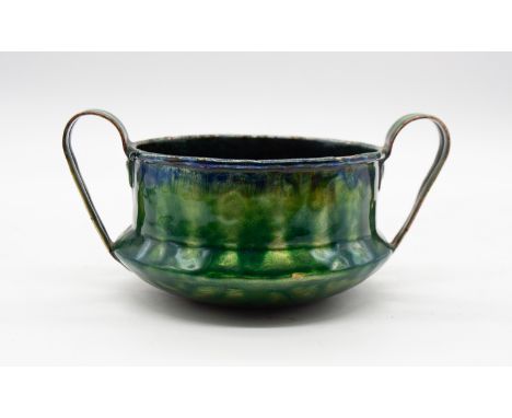 An Arts & Crafts style 20th century enamel over copper twin-handled bowl, of stylish form and in green and blue colourway. (U
