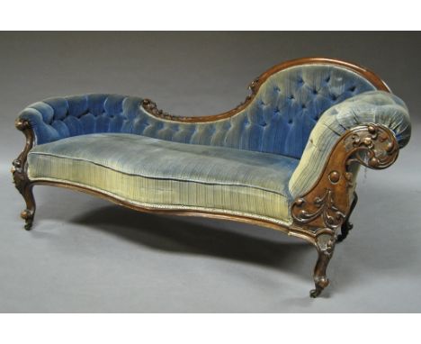A Victorian button back carved mahogany chaise longue, shaped front, decorated with floral motifs, rasied on casters.  CONDIT