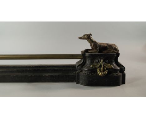 A French patinated metal fire surround, 19th century, the ends modelled as seated dogs, on acorn and leaf applied pedestals, 