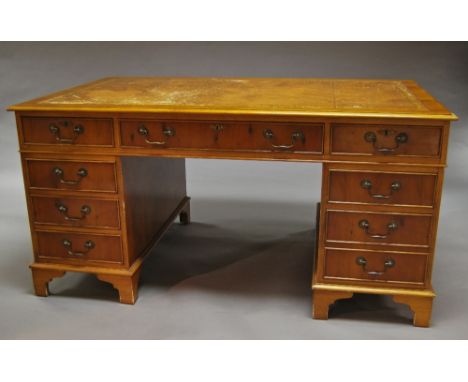 A Victorian style yew wood leather top pedestal desk, tooled leather inlaid rectangular top, above three drawers, flanked by 