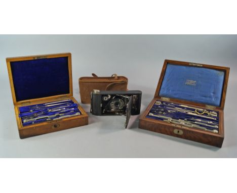 A Kodak camera, in a leather case, 17cm wide, together with two wooden cased sets of draughtsman's instruments(3) (VAT charge