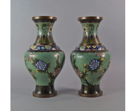 A pair of Chinese enamel vases, 20th century, decorated overall with flowers , on pale celadon grounds, 30cm high (2)