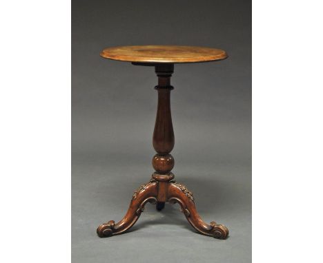 A circular oak side table, early 20th century, on turned support, above carved tripod feet, 76 cm high x 52 cm diam.