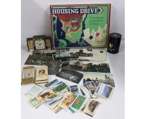 A mixed lot to include a boxed Pepys series Housing Drive board game vintage Bayard travel clock, postcards and cigarette car