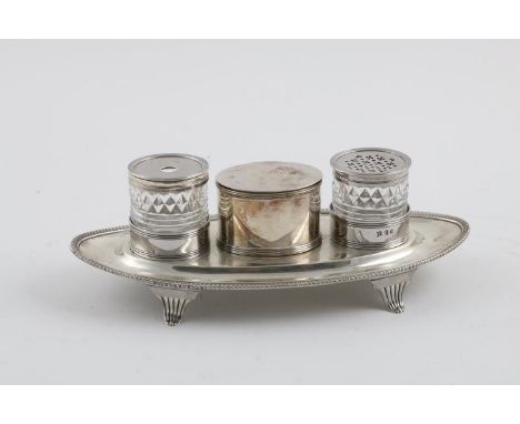 A GEORGE III BOAT-SHAPED INKSTAND. with a gadrooned rim, fluted bracket feet and a central oval box, flanked by two mounted c