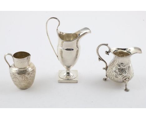 THREE MILK/CREAM JUGS:-. a George V helmet-shaped example with a loop handle and bead borders, by George Nathan &amp; Ridley 