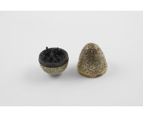 BY STUART DEVLIN:-. a late 20th century silvergilt "surprise" egg, with a textured surface, opening to reveal anodized coral 