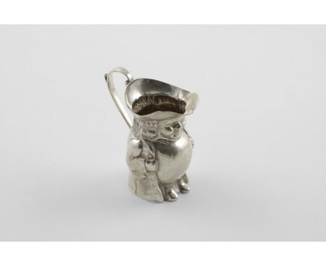 A GEORGE V NOVELTY CREAM JUG. in the form of a plump gentleman, his hat creating a flaring rim, with a loop handle and a regi