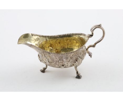 A GEORGE III SAUCE BOAT. with a scroll handle and on three hoof feet, the body chased and embossed with floral decoration,  c