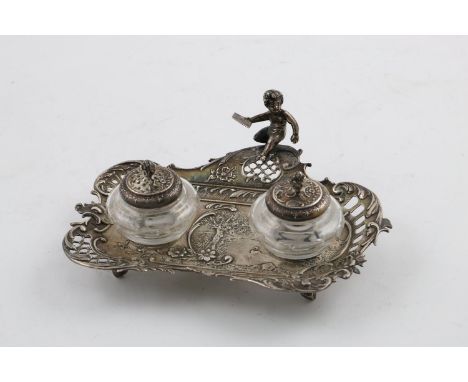 A LATE 19TH CENTURY INKSTAND. of shaped rectangular form, with a pierced floral and scroll border and a cherub holding an env