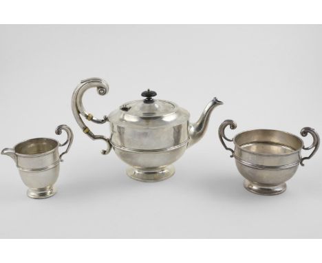 AN EDWARDIAN THREE PIECE TEA SET. of circular form, with flying scroll handles and a moulded girdle, by George Wish &amp; Co 