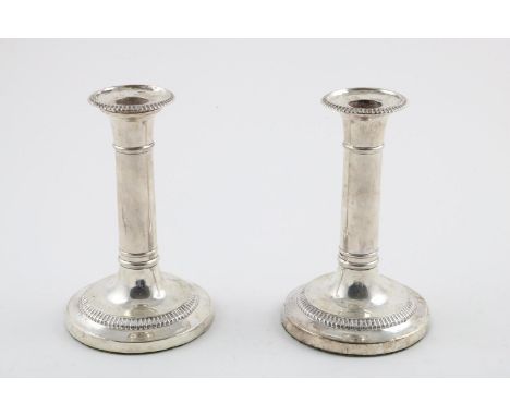 A PAIR OF GEORGE III CANDLESTICKS. with detachable nozzles and gadrooned borders (loaded bases), by John Roberts &amp; Co, Sh