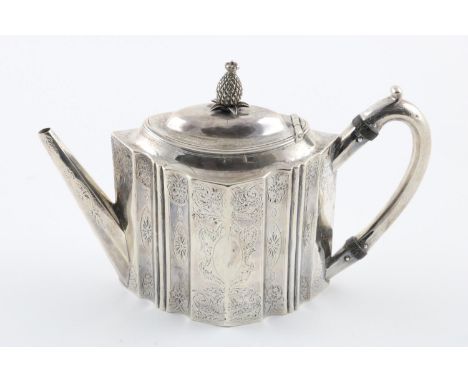 A GEORGE III TEAPOT. of shaped oval outline, with a scroll handle and a domed cover with a pineapple finial, engraved with fo