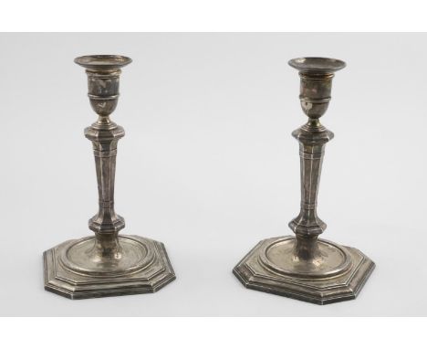 A PAIR OF EDWARDIAN CANDLESTICKS. in the 18th century style; octagonal form with panelled columns and stepped bases (loaded),