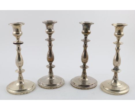 A SET OF FOUR 20TH CENTURY NORTH AMERICAN CANDLESTICKS. of baluster form with urn shaped capitals, on raised circular bases, 