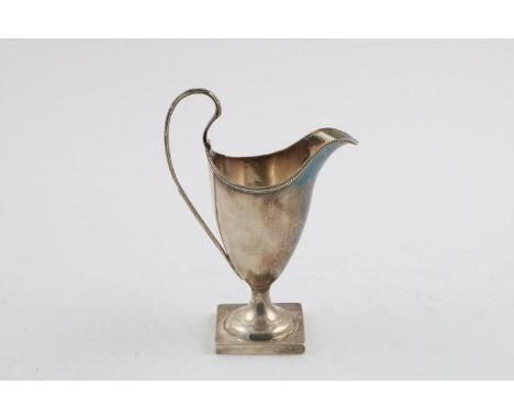 A GEORGE III HELMET-SHAPED MILK JUG. on a square pedestal base, with a loop handle and a bead border, incuse duty mark, by Jo