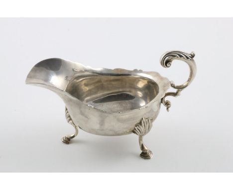 A LATE VICTORIAN SAUCE BOAT. with a wavy rim , a leaf-capped flying scroll handle and resting on 3 hoof feet, by Charles Stua
