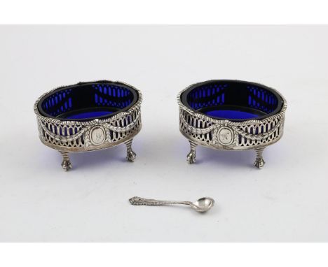 A PAIR OF GEORGE III PIERCED OVAL SALTS. on ball and claw feet, with wavy gadrooned rims, blue glass liners and decorated on 