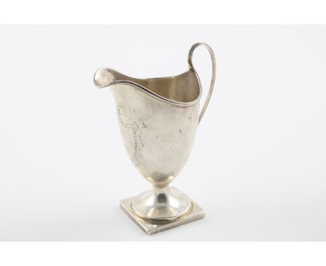 A VICTORIAN HELMET-SHAPED MILK JUG. with a loop handle, a square pedestal base and an engraved shield-shaped cartouche (vacan