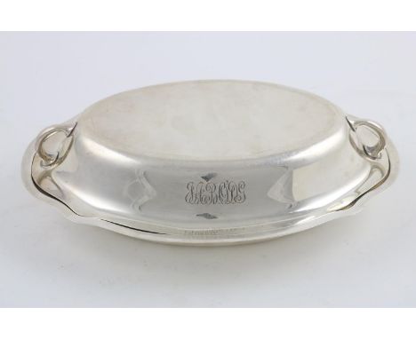 A 20TH CENTURY NORTH AMERICAN ENTREE DISH &amp; COVER. of shaped oval outline, the cover with two loop handles, initialled, b