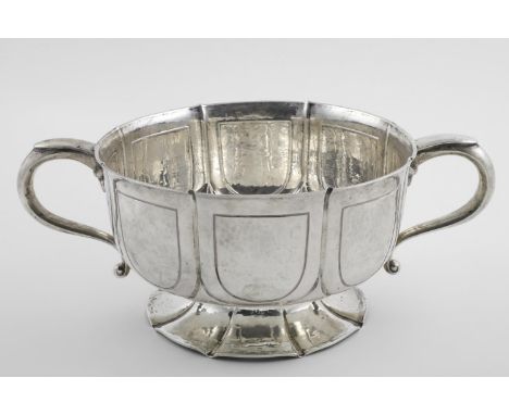 AN EDWARDIAN ARTS AND CRAFTS TWO-HANDLED BOWL. of lobed circular form, with vacant shield-shaped cartouches around the body, 