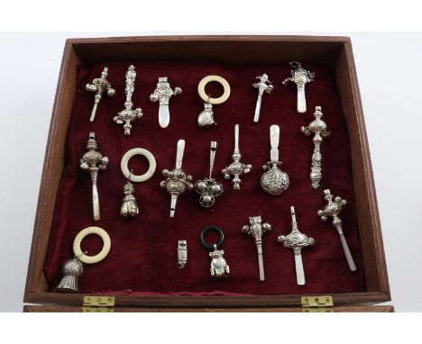 EIGHTEEN BABY RATTLES:-. in varying styles including; a cat, owl, teddy bear, a harlequin, an Art Nouveau example and 3 plate